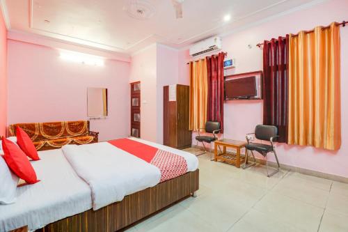 a hotel room with a bed and a desk at OYO Trimurti Palace Near Gomti Riverfront Park in Vibhuti Khand