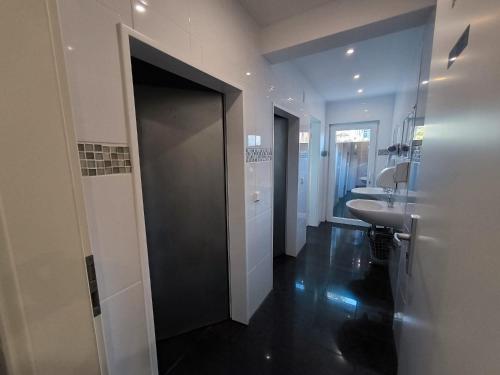 a bathroom with a sink and a toilet and a door at Pension Isabel I in Bremen