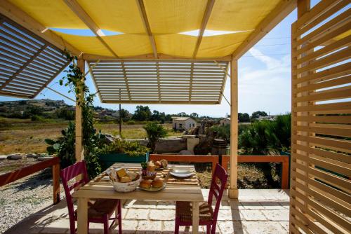 a patio with a table and chairs under awning at B&B Fermata 106 da Carolina in Siculiana Marina