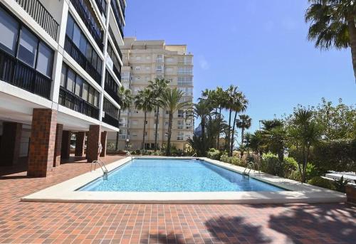 una piscina frente a un edificio en Apartamentos Colón - Grupo Antonio Perles en Calpe