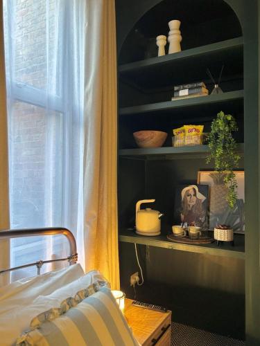 a bedroom with a bed and a shelf with dishes at The Wellesley in Belfast