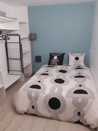 a bedroom with a large bed with a comforter at Charmante maison dans le Gers, proche lac et centre-ville in LʼIsle-Jourdain