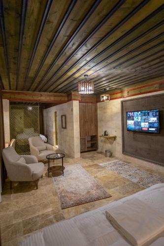 a living room with a couch and a tv at Uçhisar Premium in Nevsehir
