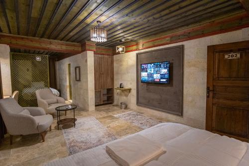 a bedroom with a bed and a tv on the wall at Uçhisar Premium in Nevsehir