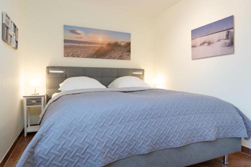 ein Schlafzimmer mit einem blauen Bett mit zwei Kissen in der Unterkunft Residenz Kurparkhöhe Appartement Meerzeit in Scharbeutz