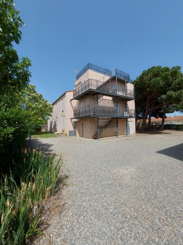 ein großes Gebäude mit einem Balkon an der Seite in der Unterkunft soleil catalan terrasse panoramique ok chéques vacances 4pers wifi 65m2 jardin parking 2ch 2km mer in Latour-Bas-Elne