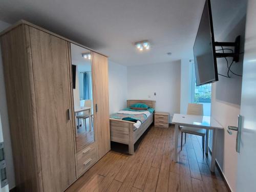 Schlafzimmer mit einem Bett, einer Kommode und einem Schreibtisch in der Unterkunft Pension Isabel I in Bremen