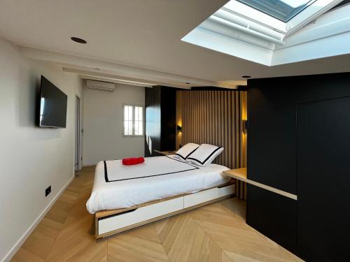 um quarto com uma cama e uma clarabóia em Rooftop unique vue mer / Vieil Antibes em Antibes