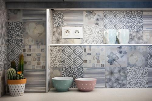 a shelf with three bowls in a room with tiles at Newly Renovated Cozy Studio Downtown Athens in Athens