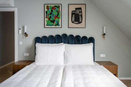 a bedroom with a bed with a blue headboard at numa I Terra Apartments in Vienna