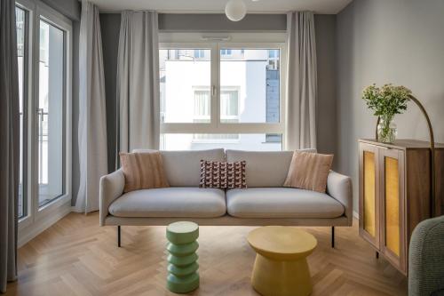 a living room with a couch in front of a window at numa I Terra Apartments in Vienna