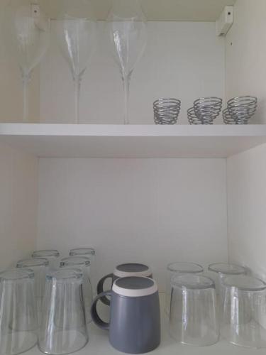 a shelf with a row of dishes and cups at Cosy Apartment with Balcony and Breakfast in Bishop Auckland