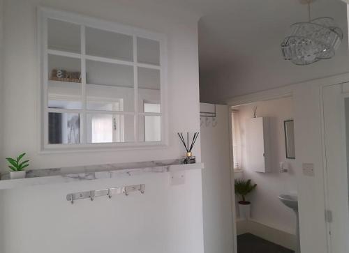 biała kuchnia ze zlewem i oknem w obiekcie Cosy Apartment with Balcony and Breakfast w mieście Bishop Auckland
