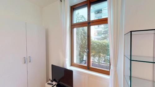 ein Wohnzimmer mit einem Fenster und einem TV in der Unterkunft Unique Serviced Living @ Airport Line in Basel