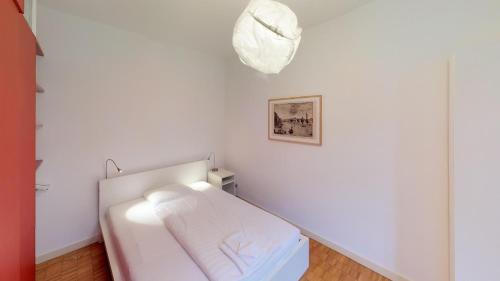 a white room with a bed and a picture on the wall at Unique Serviced Living @ Airport Line in Basel