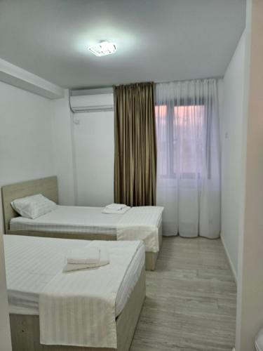 ein Hotelzimmer mit zwei Betten und einem Fenster in der Unterkunft Perdemi in Galaţi