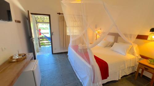 a bedroom with a bed with a mosquito net at VELINN Caravela Pousada Ilhabela in Ilhabela