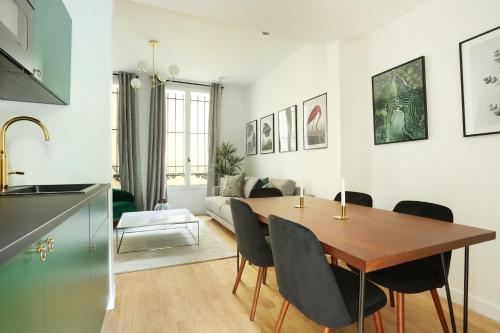 Il dispose d'une cuisine et d'un salon avec une table et des chaises en bois. dans l'établissement Apartment Center of Paris by Studio prestige, à Paris