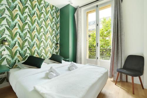 une chambre avec un grand lit blanc et une chaise dans l'établissement Apartment Center of Paris by Studio prestige, à Paris