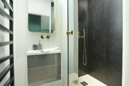une salle de bain avec une douche, un lavabo et un miroir dans l'établissement Apartment Center of Paris by Studio prestige, à Paris