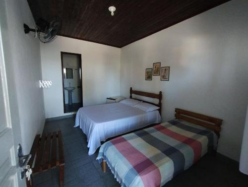 a bedroom with two beds in a room at Pousada Tropicália Tranquilidade a Beira Mar in Santa Cruz Cabrália