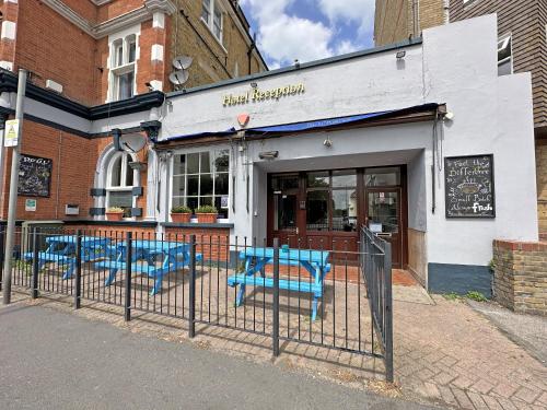 a restaurant with blue chairs in front of a building at Royal Hotel Sheerness in Sheerness