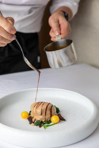 a person eating a dessert on a white plate at Casa Baglioni Milan - The Leading Hotels of the World in Milan