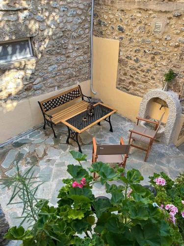a patio with a bench and a table and chairs at Lucy's Home in Riglia