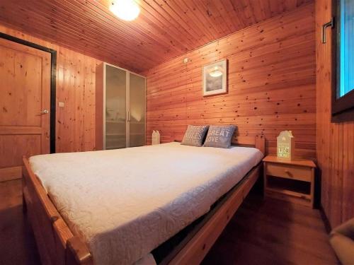 um quarto com uma cama num chalé de madeira em Chalet De Ravers em Durbuy
