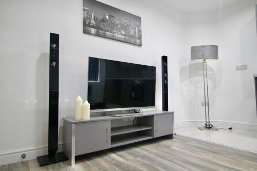 a living room with a flat screen tv and speakers at Roundhay Flat Duplex - Sleeps 2 in Roundhay
