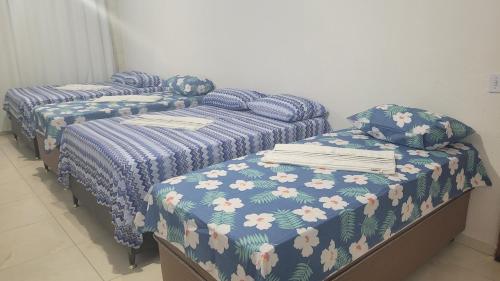 two twin beds in a room with blue comforter at Suite Pajuçara in Maceió