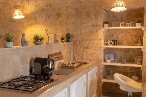 a kitchen with a counter with a stove and a sink at B&B Puglia - Mi Casa Luxury Suite - Room with Hydromassage Pool in Turi