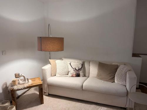 a living room with a white couch and a table at Ferienwohnung Agena in Schliersee