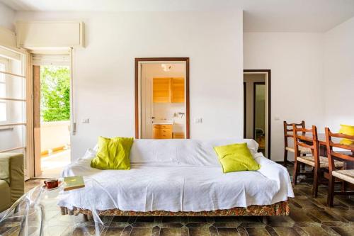 1 cama blanca con almohadas amarillas en una habitación en Valsassina Paradise Apartment - free ski bus just below the building, en Cassina Valsassina