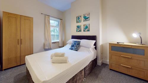 a bedroom with a large bed and a dresser at K Suites - Park Street in Grimsby