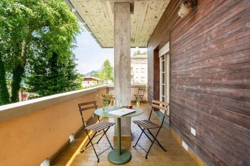 a patio with a table and chairs on a balcony at Valsassina Paradise Apartment in Cassina Valsassina