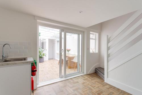 a kitchen with sliding glass doors leading to a dining room at 2 Bedroom Apartments in Covent Garden Sleeps 6 in London