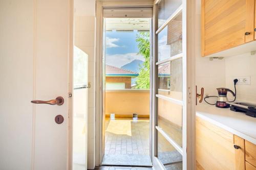 a kitchen with a door leading to a balcony at Valsassina Paradise Apartment in Cassina Valsassina