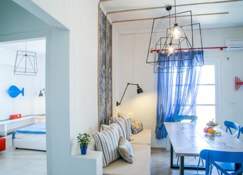 a dining room with a table and blue chairs at Eos Villa in Imerovigli