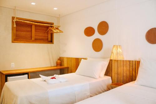 a bedroom with two beds and a window at Pousada Vila de Pedra in Jericoacoara