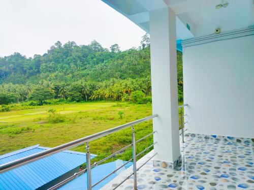 a balcony of a house with a view of a field at ANIBESH HOTEL in Havelock Island