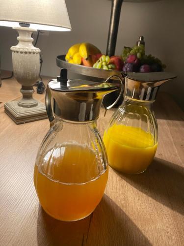 una jarra de zumo de naranja y un bol de fruta en Le Domaine Des Trois Chênes, 