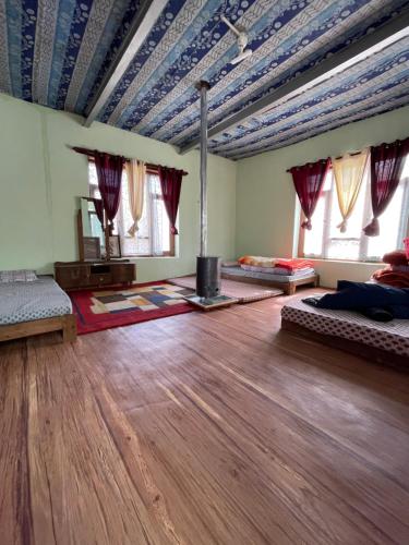 a room with two beds and a wooden floor at SpitiDiaries Homestay in Kaza