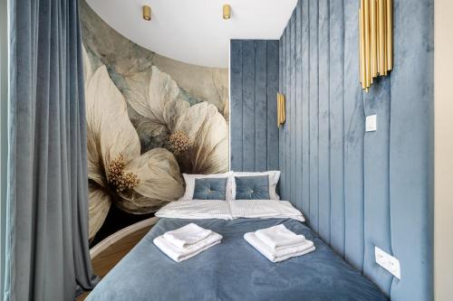 a bedroom with a blue bed with towels on it at 2-Bedroom DeLux Apartment with Private Sauna WWA25 in Warsaw