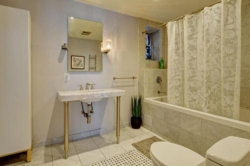 a bathroom with a sink and a tub and a toilet at Sublime Residence Downtown Montreal in Montréal