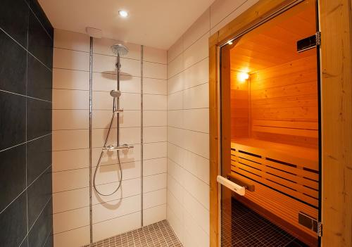 une salle de bain avec une douche avec une porte vitrée dans l'établissement CHALET KAILA, à Morzine