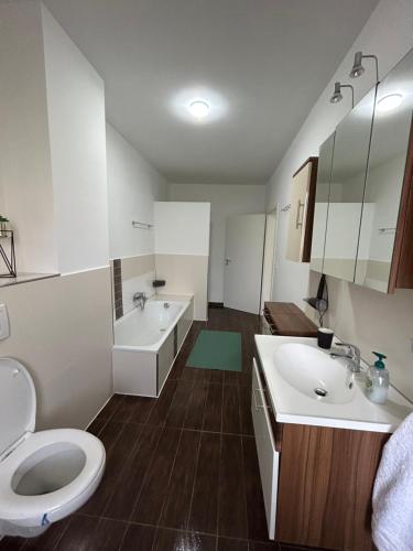 a bathroom with two sinks and a toilet at Apartment am Gustav-Lübcke Museum - Hbf in Hamm
