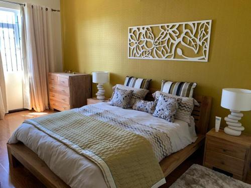 - une chambre avec un grand lit et deux lampes dans l'établissement Inak villa, à Grand Baie