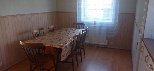 a dining room with a table and chairs and a window at Villa Skomakar Kramfors in Kramfors