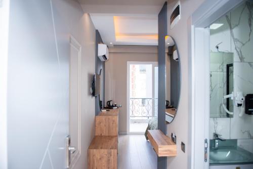 pasillo con baño con lavabo y espejo en TEKER LUXURY HOTEL, en Mezitli